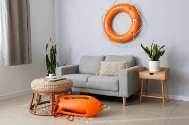 Yaşam şamandırası, yemek ve kanepesi olan modern oturma odasının içinde.