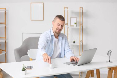 Odadaki kablosuz taşınabilir hoparlörü açan adam.