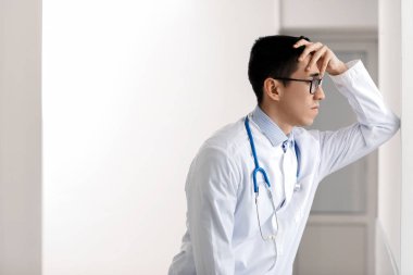 Erkek Asyalı doktor hastanede endişeleniyor.