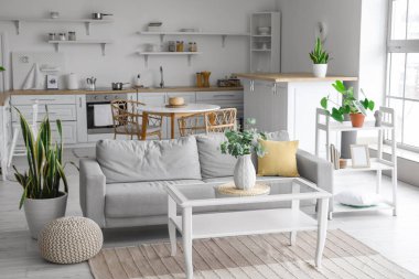 Modern tezgahları, yemek masası ve rahat kanepesi olan şık bir oda.