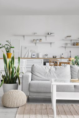 Şık mutfak içinde rahat bir kanepe ve cam bir masa.