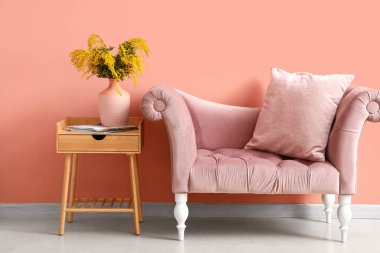 Masada mimoza çiçekleri, odanın içinde de kanepe olan vazo.