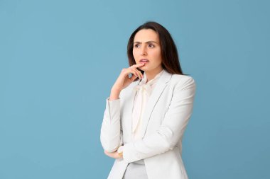 Mavi arka planda düşünceli genç sekreterin portresi.