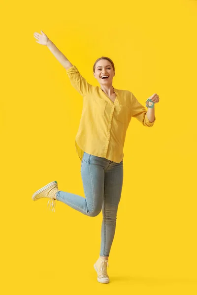 Sarı Arka Planda Evden Anahtarı Olan Mutlu Genç Bir Kadın — Stok fotoğraf