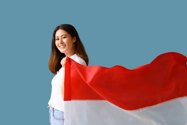 蓝色背景上悬挂印度尼西亚国旗的年轻亚洲妇女 — 图库照片
