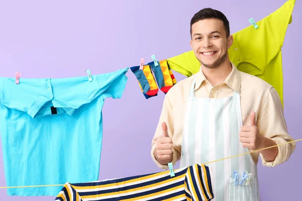 Young Man Hanging Laundry Showing Thumbs Lilac Background — Stock Photo, Image