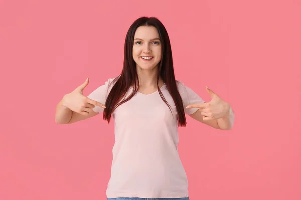 Jonge Vrouw Wijst Naar Shirt Roze Achtergrond — Stockfoto