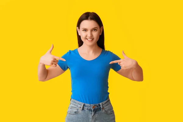 Jonge Vrouw Wijzend Naar Blauw Shirt Gele Achtergrond — Stockfoto