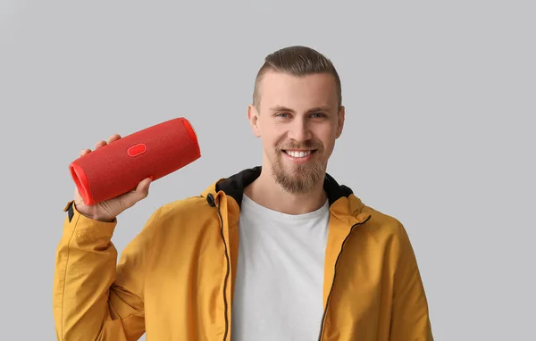 Glimlachende Man Met Moderne Draadloze Draagbare Luidspreker Grijze Achtergrond — Stockfoto