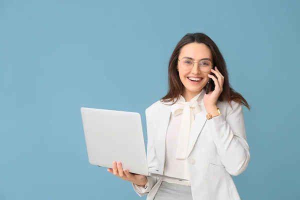 Retrato Jovem Secretário Com Laptop Falando Por Telefone Fundo Azul — Fotografia de Stock