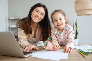 Küçük kızıyla evde çalışan genç bir anne.