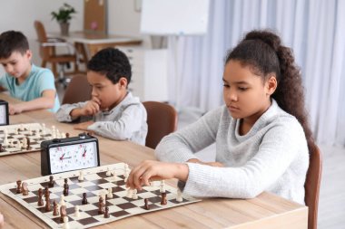 Kulüpte turnuvada satranç oynayan küçük çocuklar.