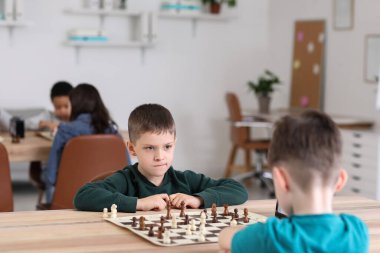 Kulüpte turnuvada satranç oynayan küçük çocuklar.