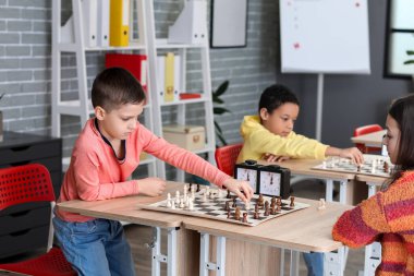 Kulüpte turnuvada satranç oynayan küçük çocuklar.