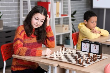Kulüpte turnuvada satranç oynayan küçük çocuklar.