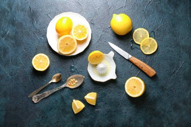 Koyu arkaplanda seramik sıkacağı ve limonlar