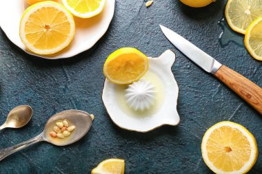 Koyu arkaplanda seramik sıkacağı ve limonlar