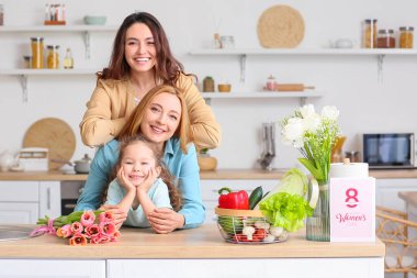 Mutlu genç bir kadın, küçük kızı ve annesi evde. Uluslararası Kadınlar Günü kutlamaları