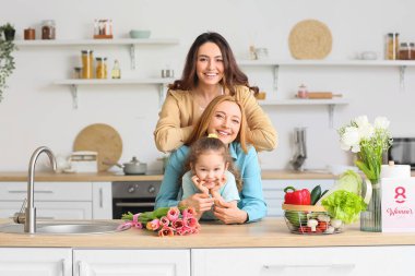 Mutlu genç bir kadın, küçük kızı ve annesi evde. Uluslararası Kadınlar Günü kutlamaları