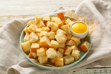 Çıtır çıtır ekmek ve ahşap masada lezzetli bir sos tabağı.