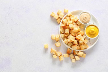 Kıtır kıtır ekmek tabağı ve beyaz arka planda lezzetli soslar, üst manzara.