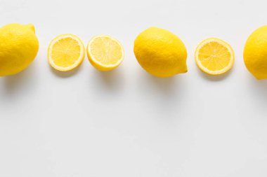Beyaz arka planda olgun limonlar ve dilimler, üst görünüm