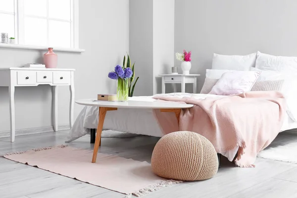 モダンな家具と美しいヒヤシンスの花と光の寝室のインテリア — ストック写真