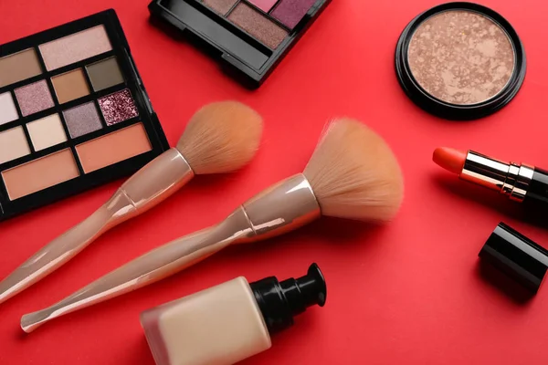 Kırmızı Arka Planda Kozmetik Ürünleri Makyaj Fırçaları Ile Kompozisyon — Stok fotoğraf