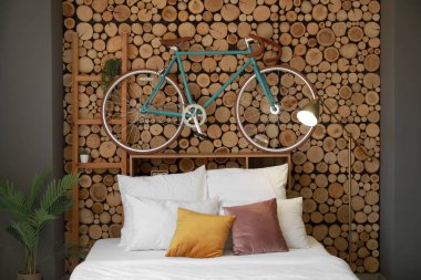 Tahta duvarda asılı rahat bir yatak ve bisiklet.