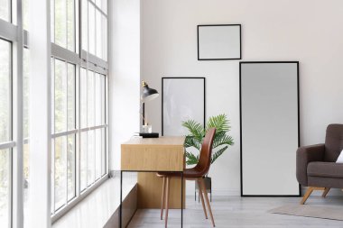 Ayna, koltuk ve büyük pencerenin yanındaki iş yeriyle aydınlatma odasının içinde.