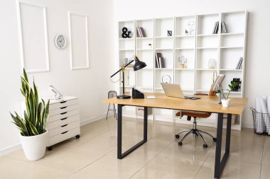 Işık ofisinin içinde dizüstü bilgisayarı ve lambası olan modern işyeri