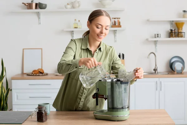 Νεαρή Γυναίκα Ρίχνει Νερό Στη Μηχανή Του Καφέ Στην Κουζίνα — Φωτογραφία Αρχείου