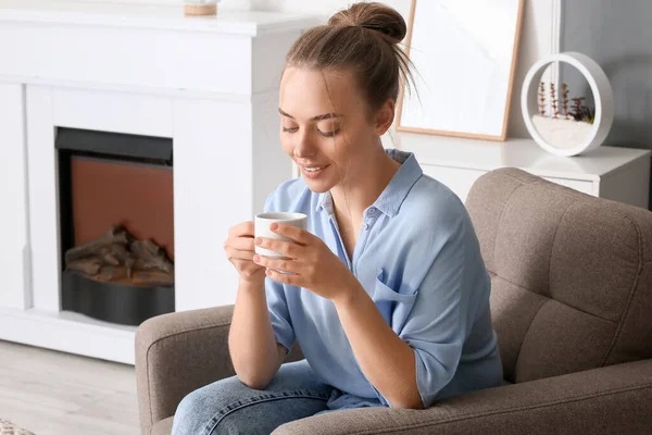 Jonge Vrouw Met Kopje Smakelijke Koffie Zitten Fauteuil Thuis — Stockfoto