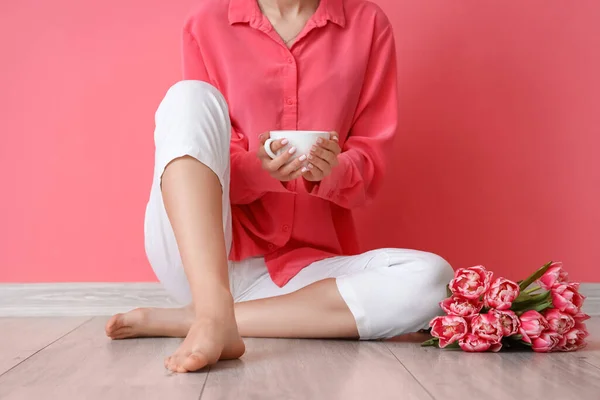 Босонога Жінка Чашкою Чаю Тюльпанів Сидить Біля Рожевої Стіни — стокове фото