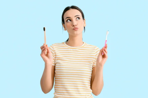 Thoughtful Young Woman Toothbrushes Blue Background — Stock Photo, Image