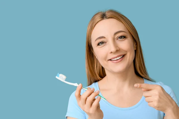 Mavi Arka Planda Diş Fırçası Olan Güzel Olgun Bir Kadın — Stok fotoğraf