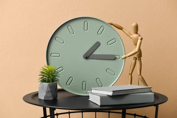 部屋のカラーウォールの近くの現代的な時計 マネキンとテーブル — ストック写真