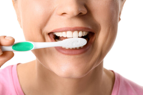 Красивая зрелая женщина чистит зубы на белом фоне, крупным планом