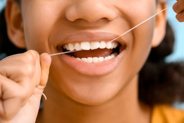 Gadis Remaja Afrika Amerika Flossing Gigi Pada Latar Belakang Biru — Stok Foto