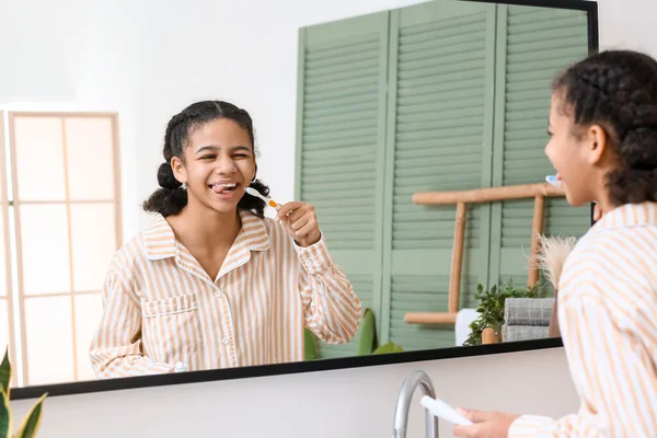 Afroamerikansk Tonåring Flicka Borsta Tänder Nära Spegel Badrummet — Stockfoto