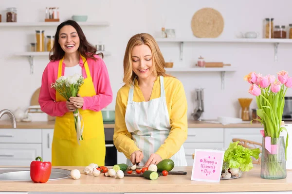 Genç bir kadın mutfakta Uluslararası Kadınlar Günü için annesini selamlıyor.