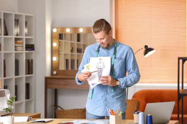 Stüdyoda çalışan genç erkek giyim tasarımcısı.