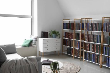 Ev kütüphanesinde kitapları ve çekmeceleri olan raf ünitesi