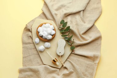 Renk arkaplanındaki pamuk topları ve okaliptüs dallarıyla kompozisyon