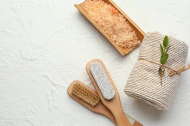 Masaj fırçası, sünger taşı, temiz havlu ve açık arkaplanda deniz tuzu