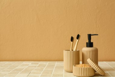 Tabakta deniz tuzu, diş fırçası ve bir şişe kozmetik ürünü var.