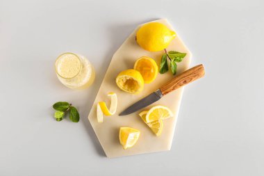 Limonlu kompozisyon, bir şişe meyve suyu ve hafif arkaplanda nane.