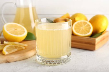 Işık masasında taze limon suyu olan bir bardak.