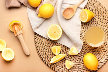 Olgun limonlar, meyve suyu ve bir bardak meyve suyu renginde ahşap arka planda.