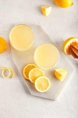 Olgun limonlu kompozisyon ve açık arkaplanda taze meyve suyu bardakları